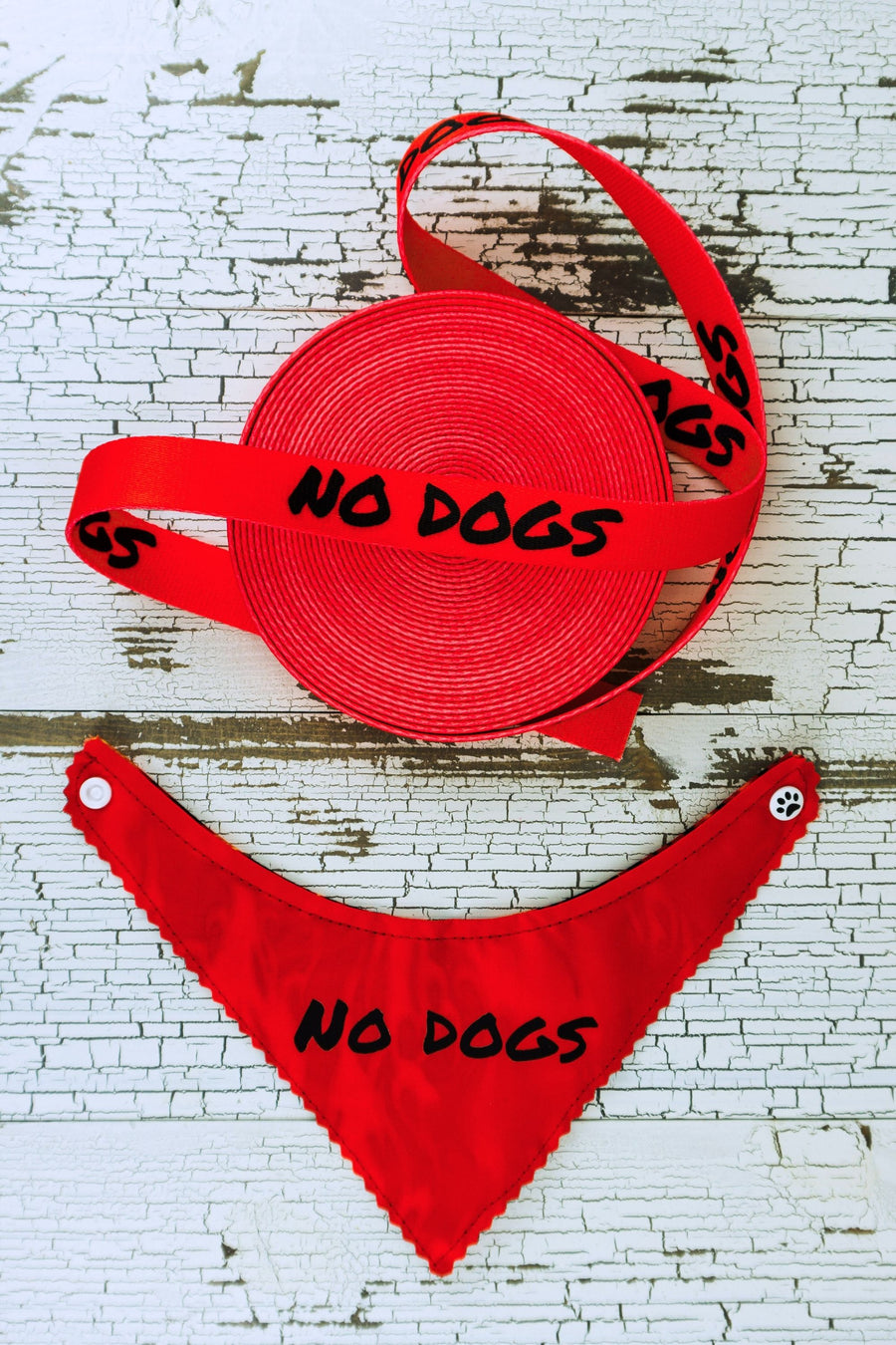 red webbing with the message "no dogs" is shown next to a red reflective bandana with the message "no dogs".