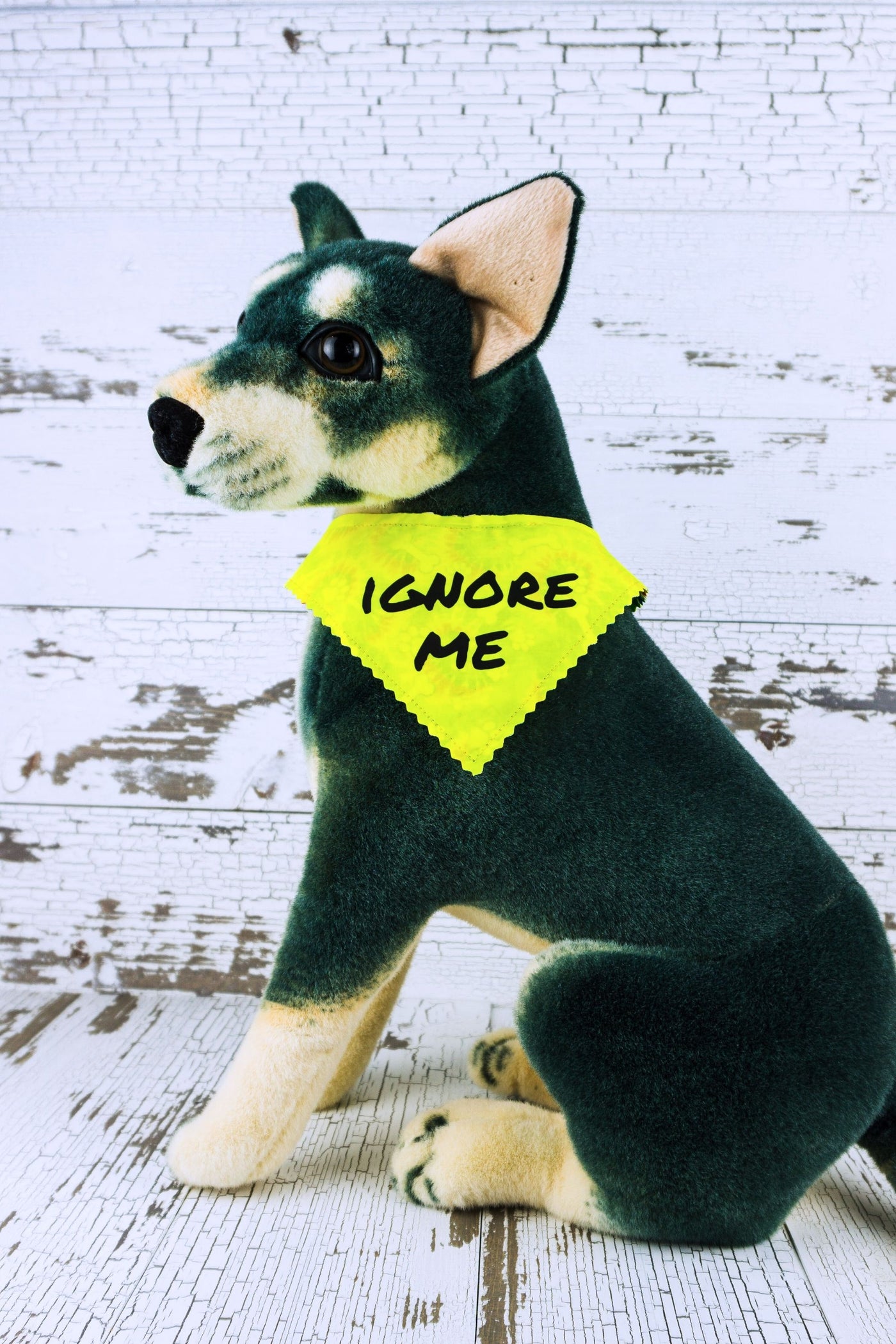 Black and brown dog mannequin with a neon yellow bandana that has text saying ignore me..