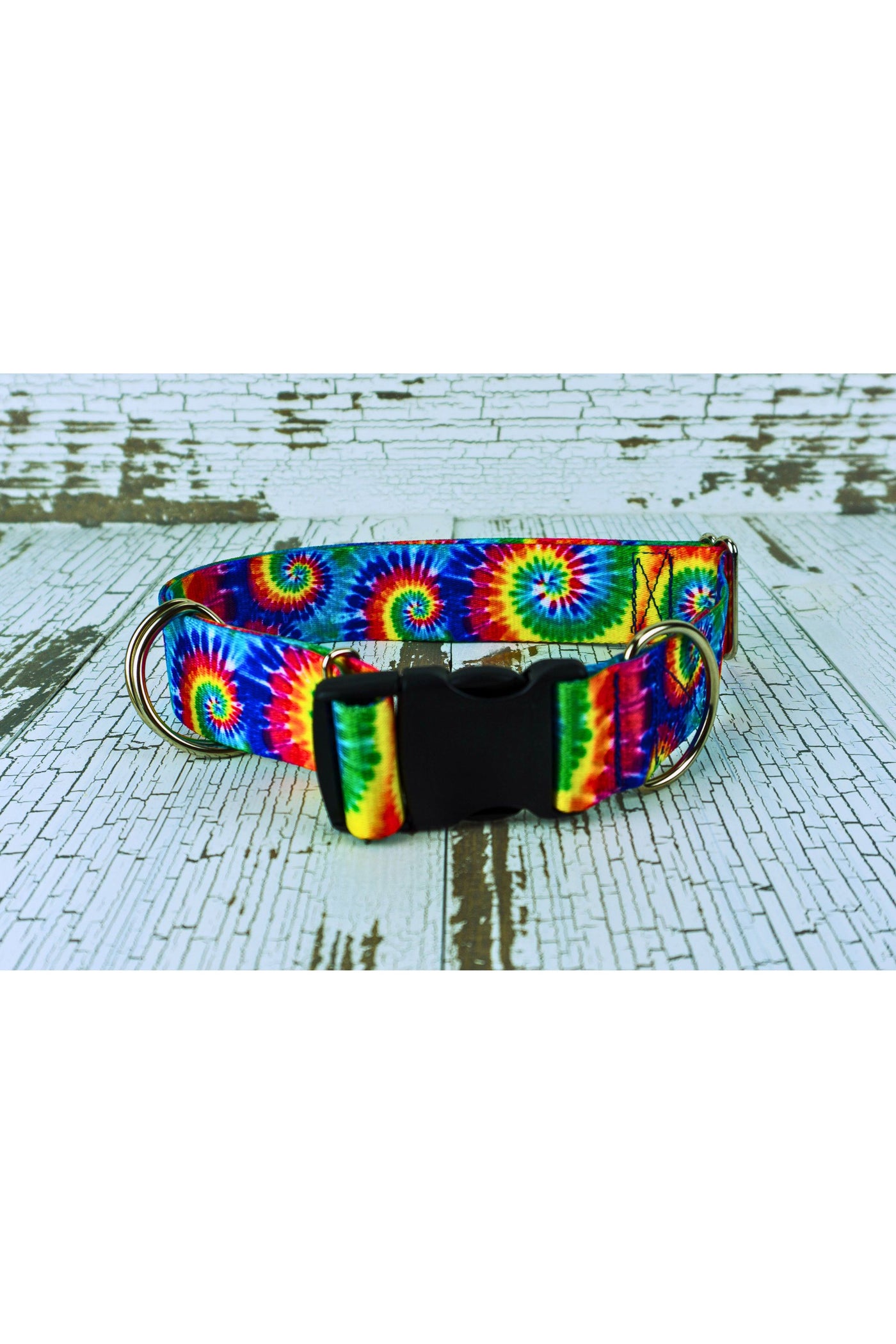 Closeup of the classic tie dye webbing medium weight hands free leash belt showing the black plastic buckle, the light weight D ring fixed next to the buckle, and the two light weight floating d rings. The belt also includes a triglide slide and keeper for easy adjustability.