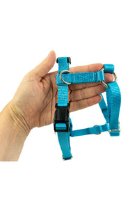 light blue small dog harness shown held in the palm of an adult hand for scale.