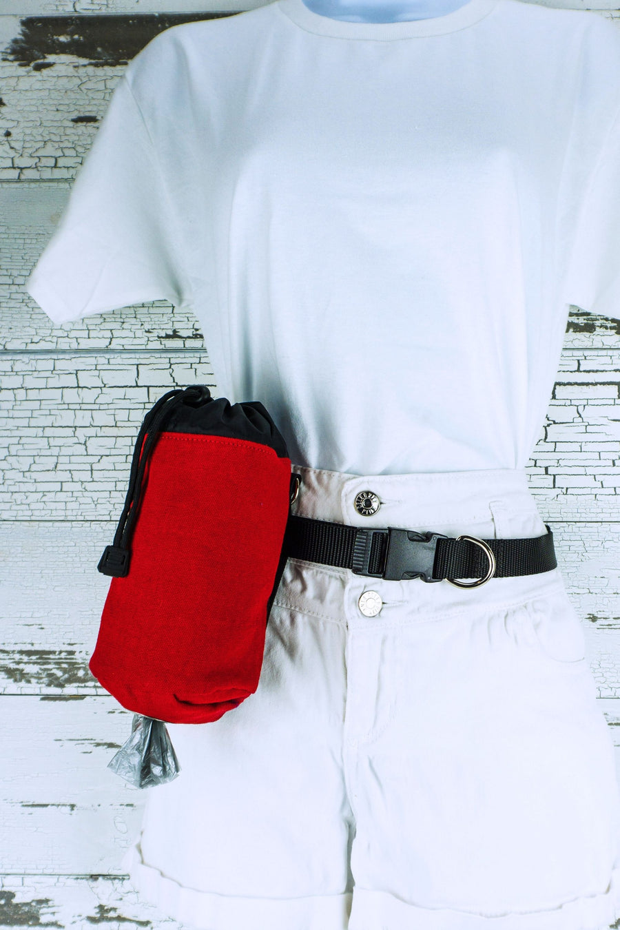 Dog walking pouch with waste bag dispenser shown in red with black lining on a light weight hands free leash belt.