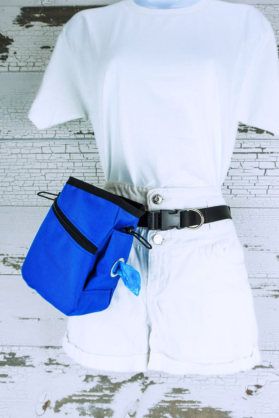 Training treat pouch with waste bag dispensers shown in royal blue with the zip front pocket on a hands free leash belt.
