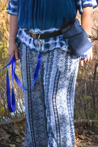 The shop owner is modeling the heavy duty hands free leash belt she uses every day, in addition she has a blue leash and treat pouch attached to the belt for the days walk.