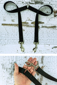 The fixed length leash coupler is shown with a hardware closeup in the palm of an adult hand.