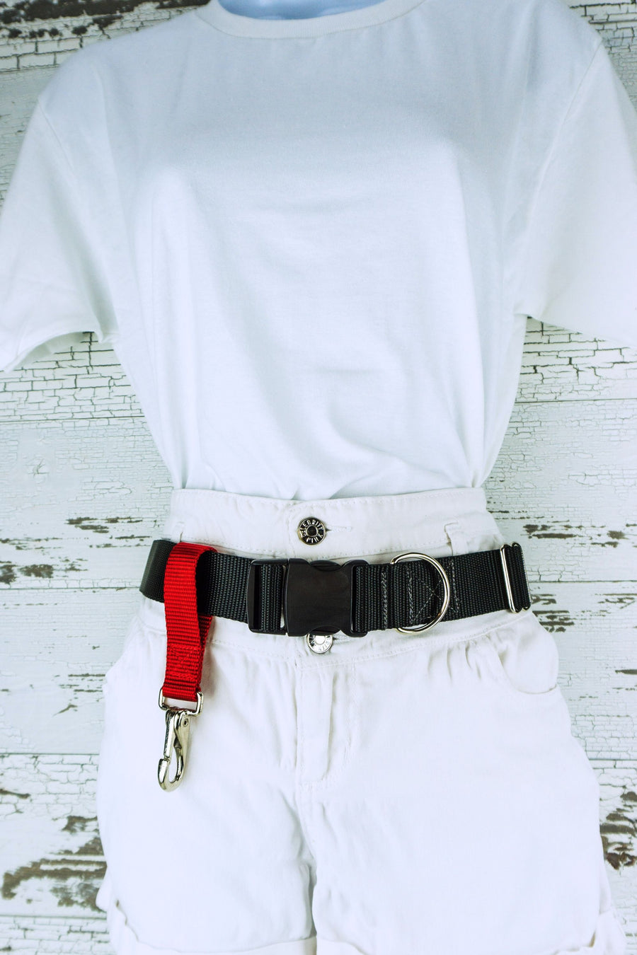 A belt add on dropped clip is shown connected to a mannequin with a hands free leash belt.