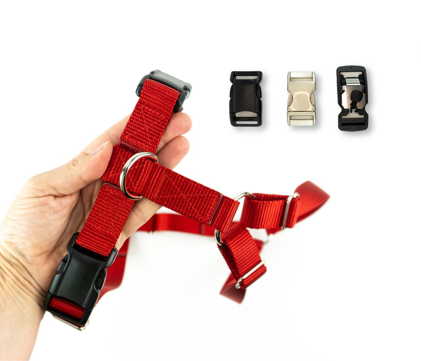 Red dog harness held in an adult hand for scale. Three options for buckles are shown, including plastic, aluminum, and magnetic.