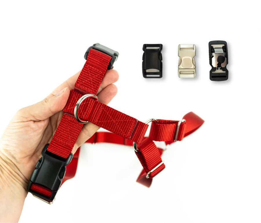 Red dog harness held in an adult hand for scale. Three options for buckles are shown, including plastic, aluminum, and magnetic.