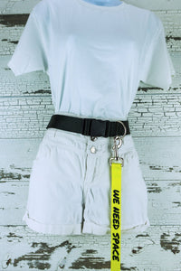 The we need space on yellow hands free leash is shown connected to a hands free waist belt on a mannequin.