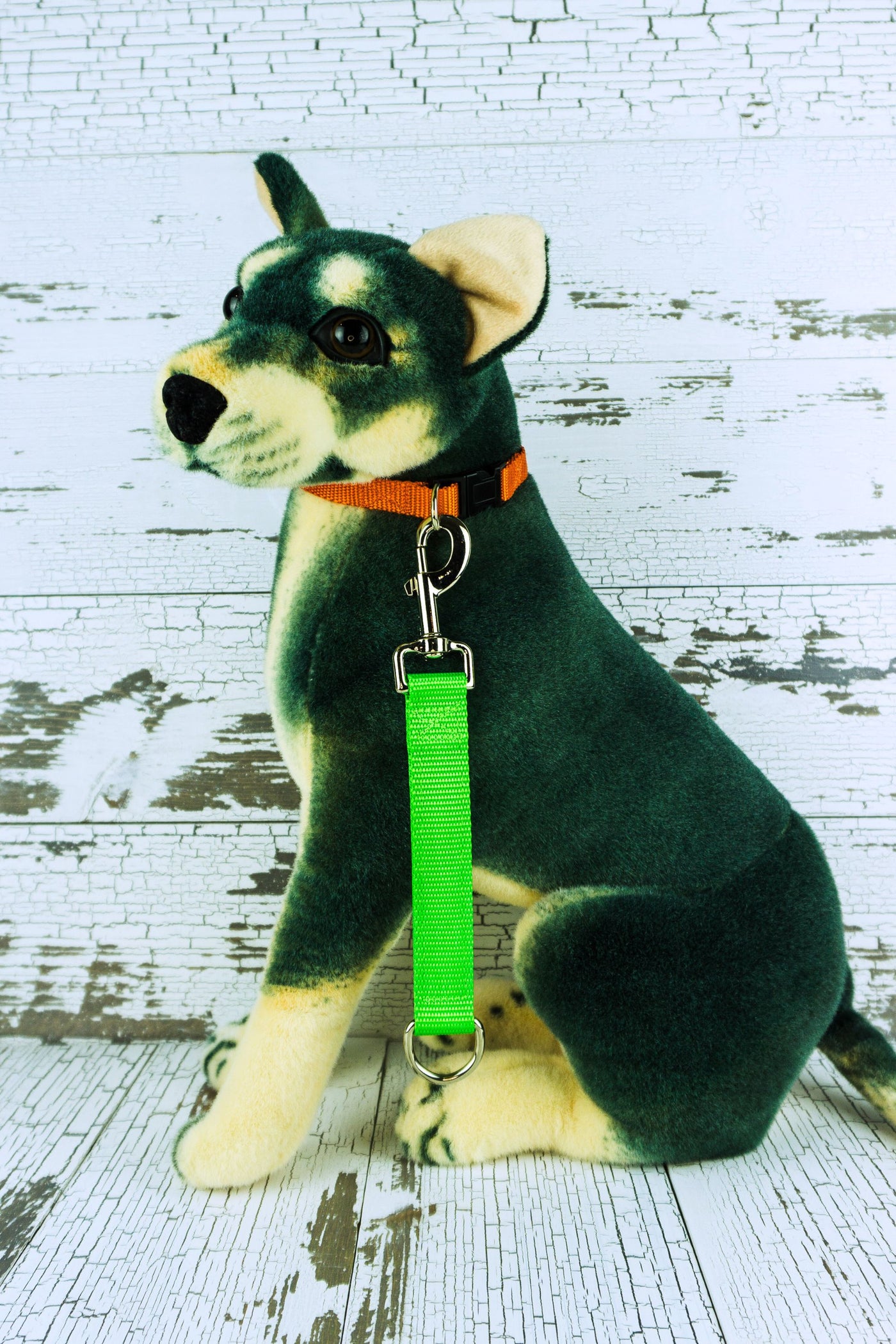 Neon green heavy duty training tab is shown clipped to the end of a dog mannequin's collar.