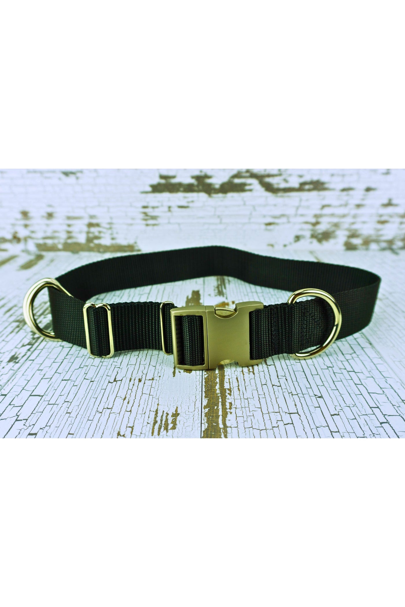 Closeup of the black webbing heavy duty hands free leash belt showing the silver aluminum buckle, the heavy duty d ring fixed next to the buckle, and the two heavy duty floating d rings. The belt also includes a triglide slide and keeper for easy adjustability.