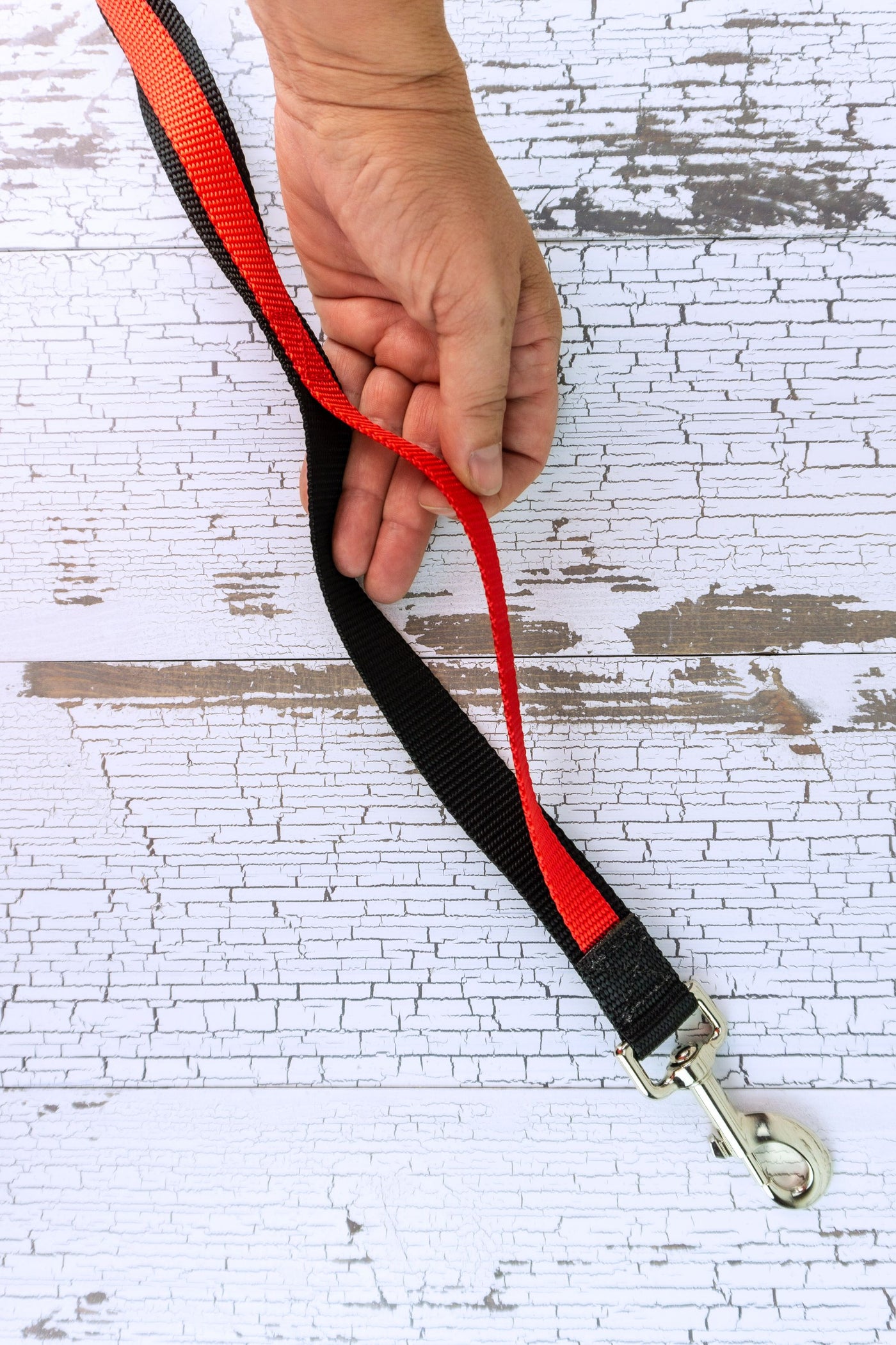 Closeup is shown of the handheld traffic leash near the dog end, showing how the two different thicknesses of webbing are sewn together in segments, leaving multiple sections available to use as handles along the length of the leash.