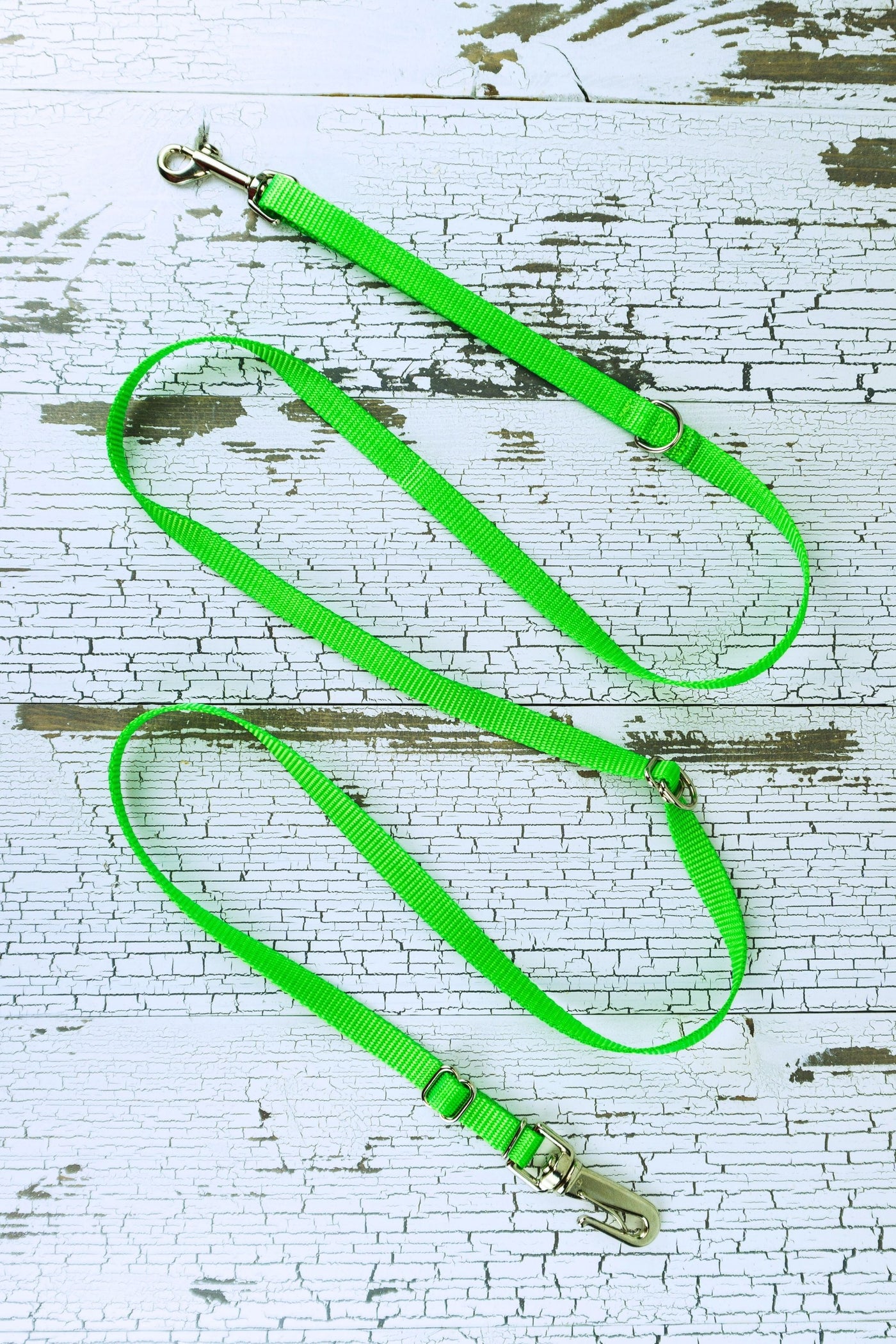 Three way adjustable and convertible leash for small dogs is shown in a flat configuration, made in a neon green webbing.