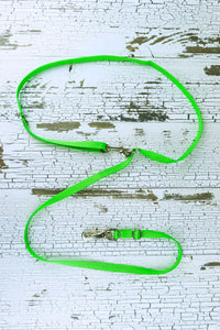 Three way adjustable and convertible leash for small dogs is shown in a flat lay with the waist belt configuration, made in a neon green webbing.