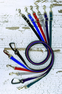 Adjustable length hands free leashes for small dogs shown here in six colors and three hardware options in a flat, swirl lay.