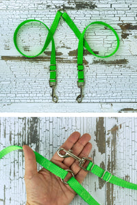 The adjustable leash coupler is shown in neon green, with a closeup of the adjustable hardware and center o ring in the palm of an adult hand for scale.