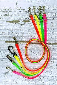 Neon adjustable length hands free leashes for small dogs shown here in a swirl lay with all neon colors and various hardware options.