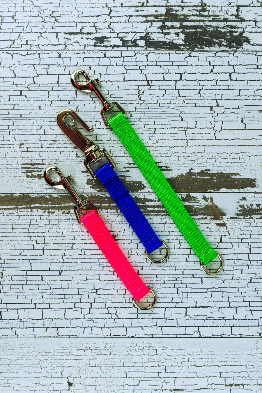 medium duty leash tabs are shown in a flat lay in the colors neon pink, blue, and neon green.