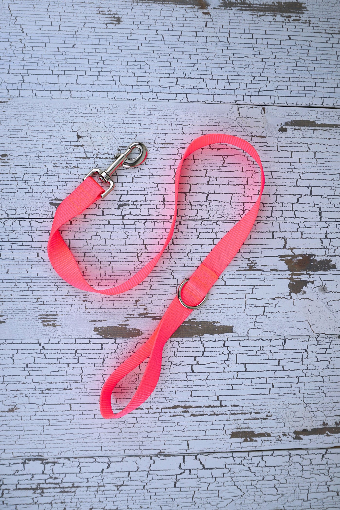 neon pink handheld short leash for medium and large dogs with a swivel snap bolt and d ring next to the loop handle.