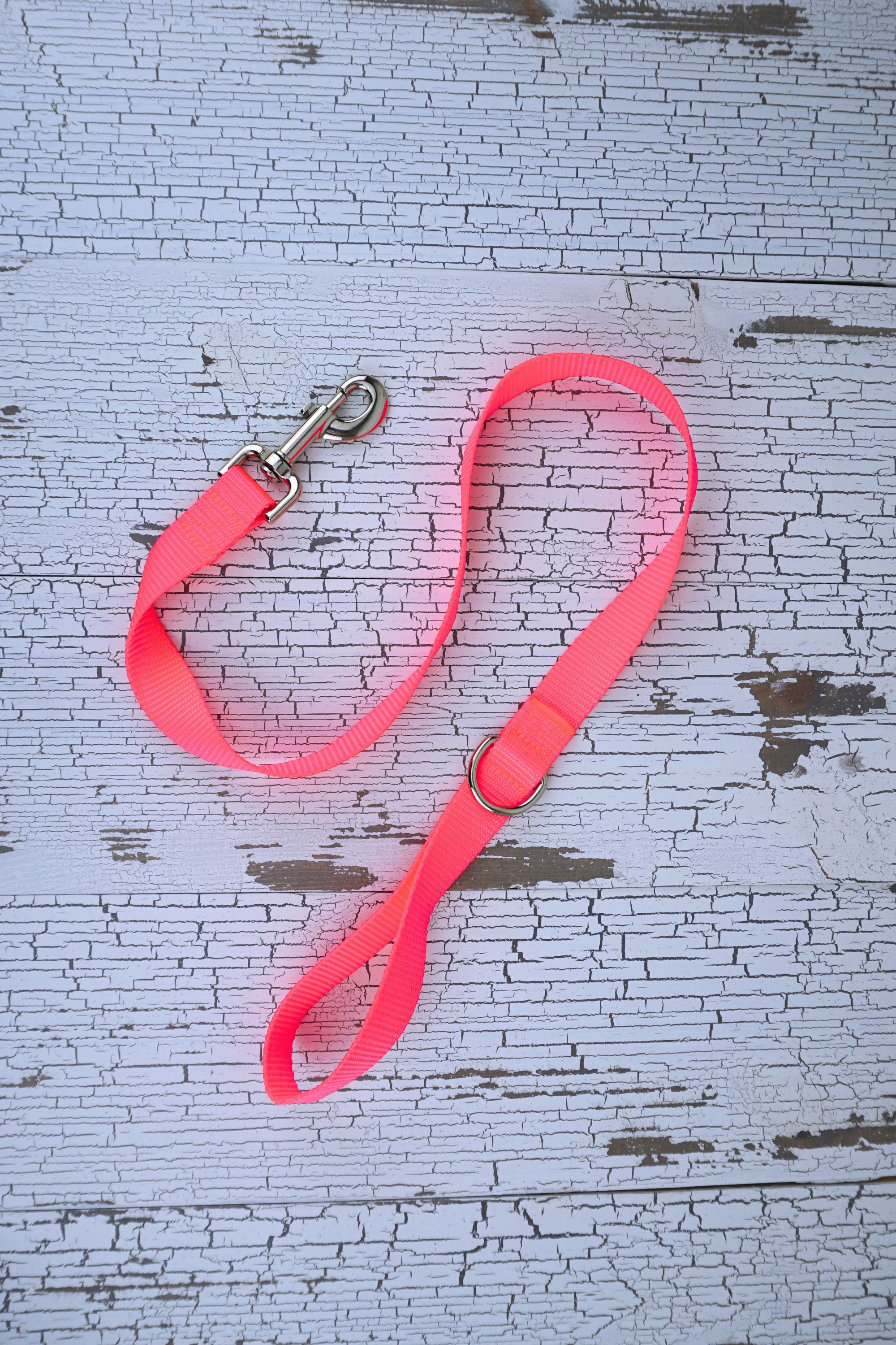 neon pink handheld short leash for medium and large dogs with a swivel snap bolt and d ring next to the loop handle.