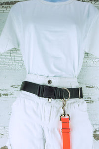 A neon orange adjustable length hands free leash shown clipped to a waist belt for hands free leashes.