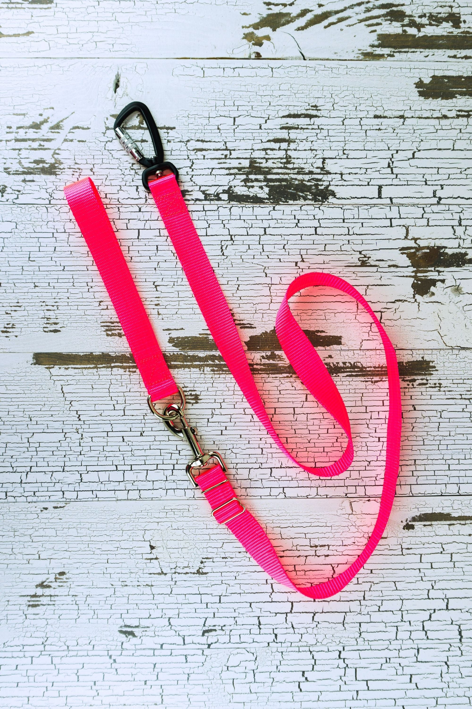 Neon pink adjustable length hands free leash shown here converted to a handheld leash by adding a leash handle with a d ring.