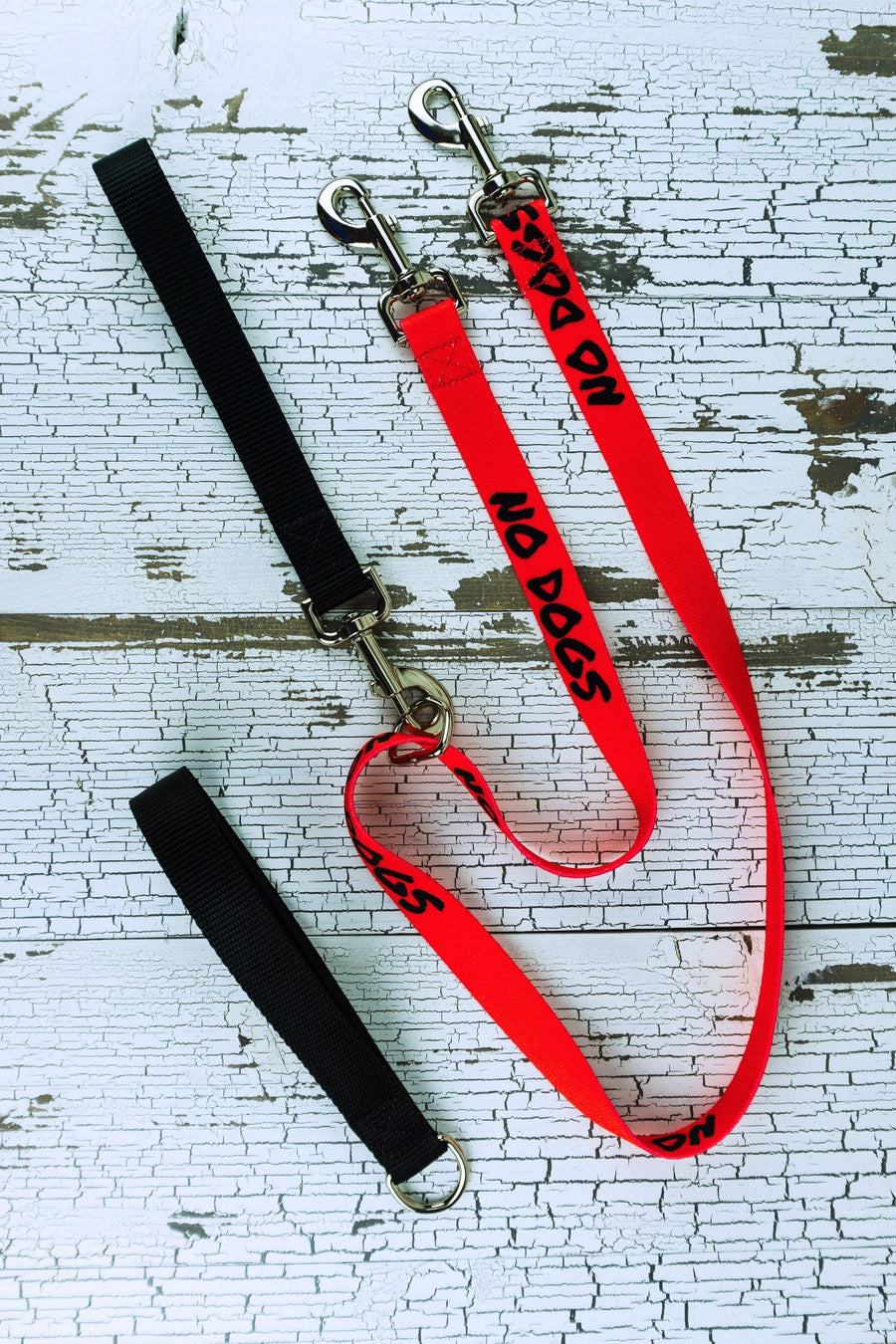The no pull leash is shown here with the safety message no dogs on red webbing with the snap bolt handle connected to the floating d ring of this fixed length leash.
