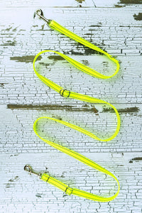 Three way adjustable and convertible leash for small dogs is shown in a flat configuration, made in a reflective neon yellow webbing.