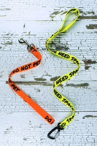 These short handheld leashes are shown here in an 18 inch do not pet on orange with a snap bolt hardware selection as well as a 48 inch we need space on yellow with an auto locking carabiner hardware option.